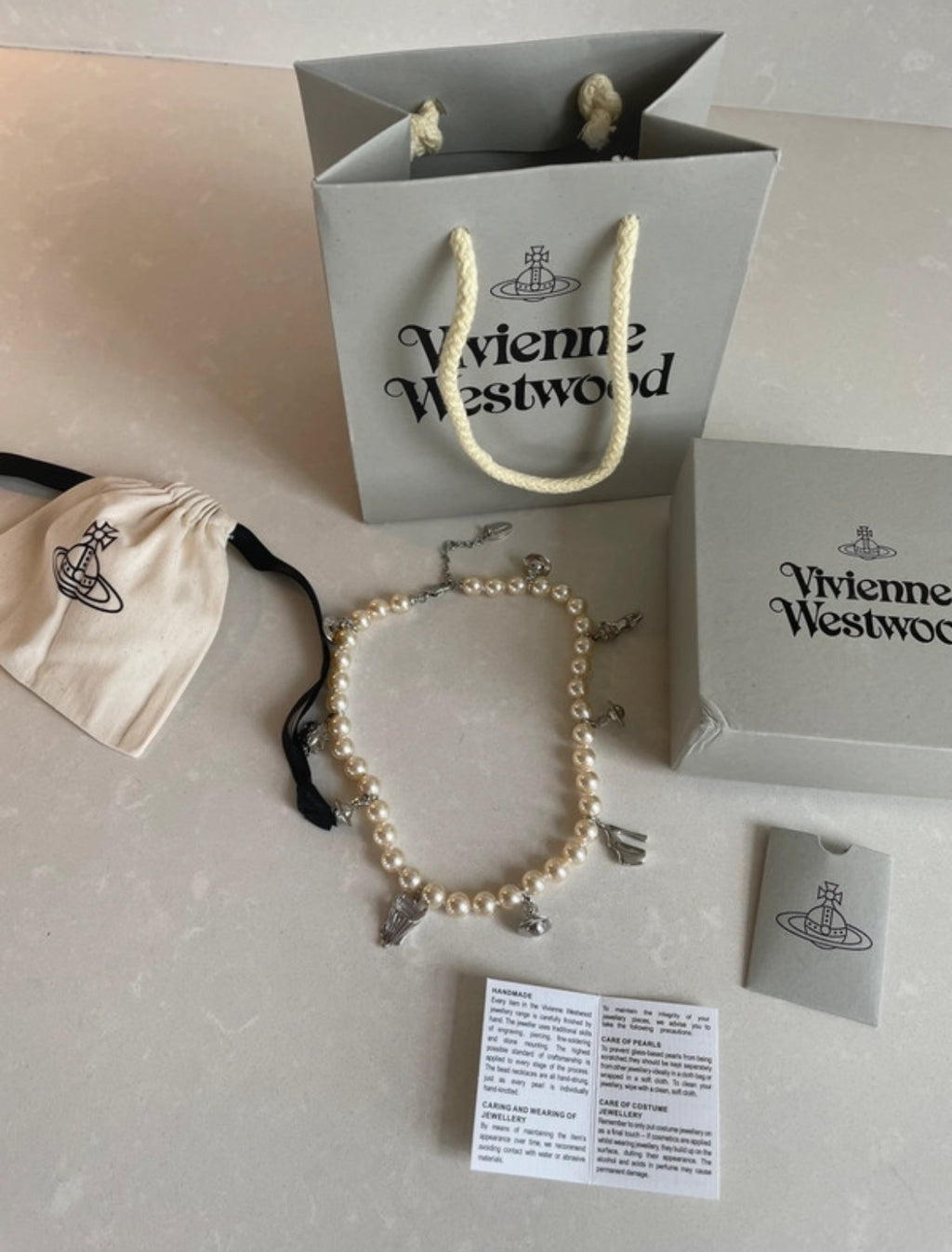 Винтидж колие Vivienne Westwood с перли и емблематичните сребристи талисмани на марката