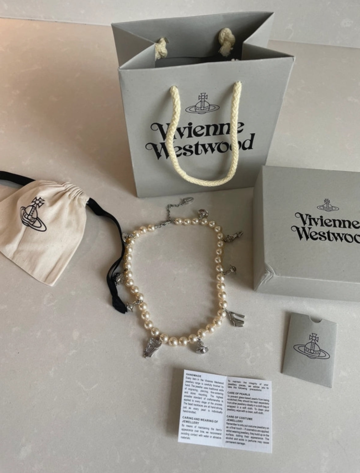 Винтидж колие Vivienne Westwood с перли и емблематичните сребристи талисмани на марката