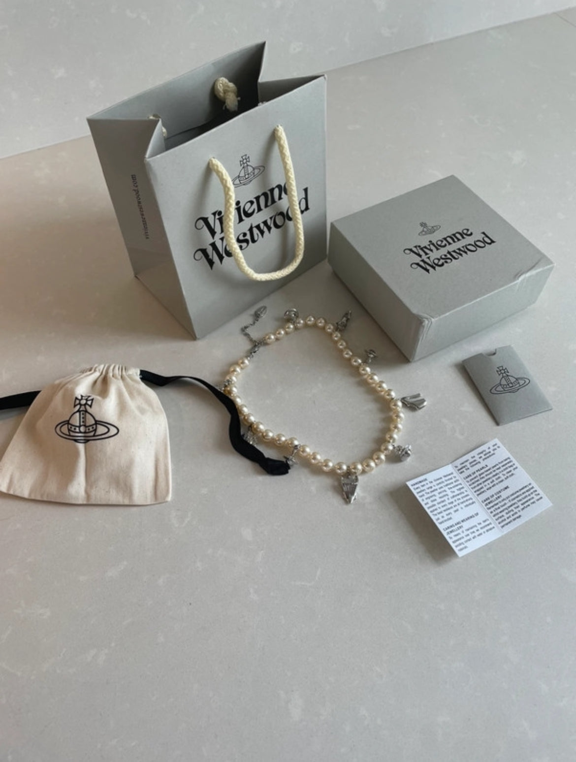 Винтидж колие Vivienne Westwood с перли и емблематичните сребристи талисмани на марката